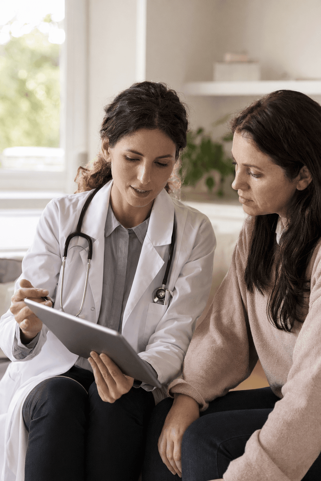A doctor reviewing results on a tablet with a patient